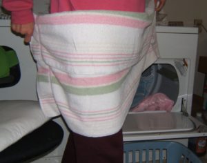 Pink and sage green bath towel wrapped around my body as a surface for folding.